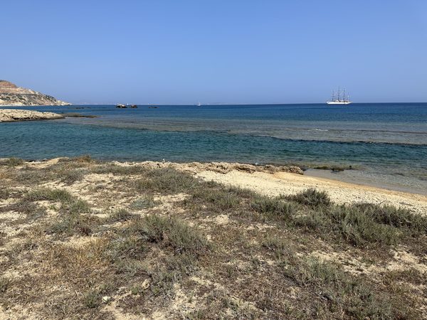 Carbonate shore platform and a tall ship offshore, Cyclades, Greece — the continuum is global.